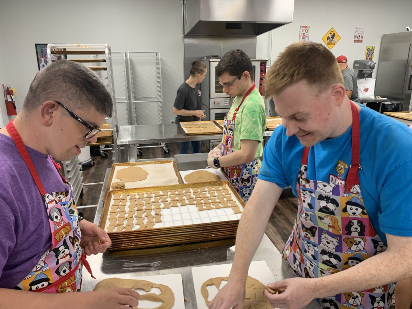 Two young people preparing dough in a kitchen.